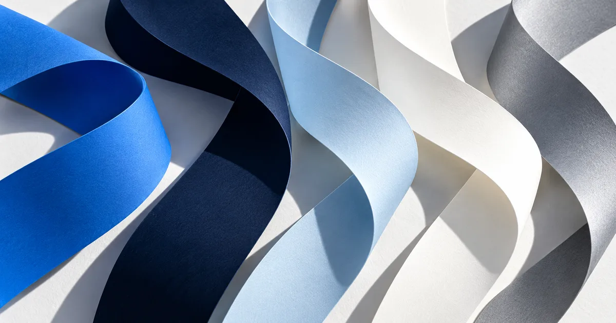 Curled paper ribbons in blue, navy, ice blue, white and grey.